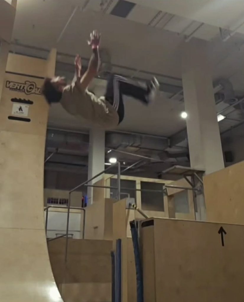 Pratiquant d'un coach de parkour de la SGH 1903 faisant un salto arrière.