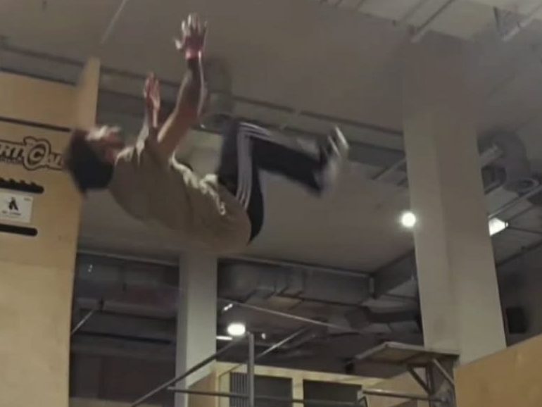 Pratiquant réalisant un salto arrière.